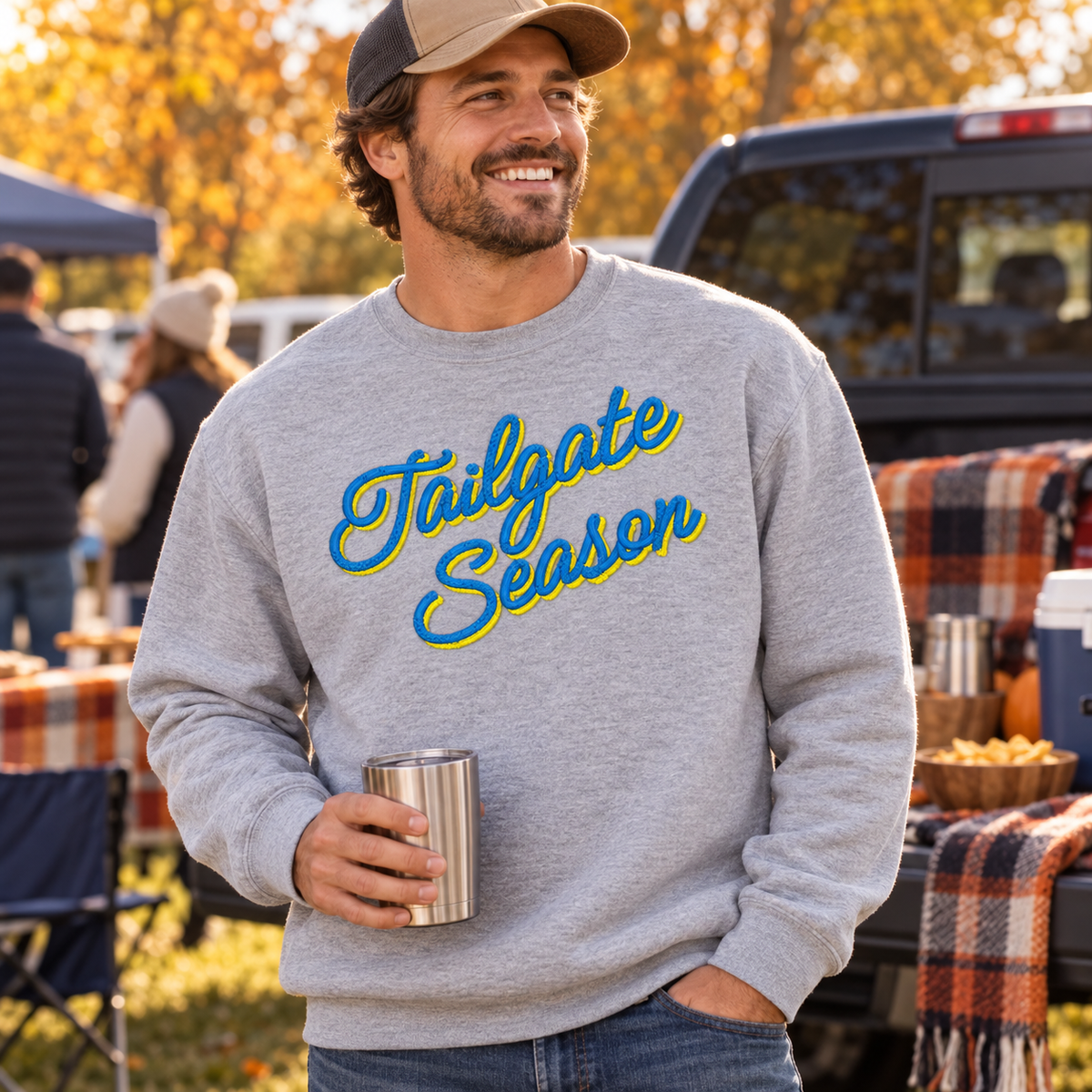 Adult Sport Grey Tailgate Season embroidered crewneck with blue and yellow thread at a fall football tailgate