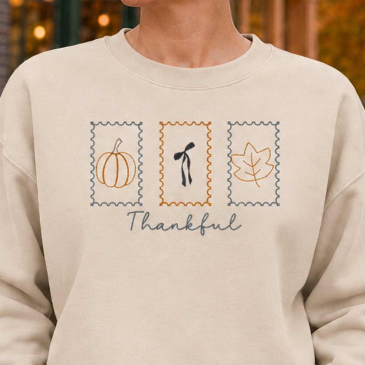 Sand sweatshirt chest detail with Thankful Stamps embroidery