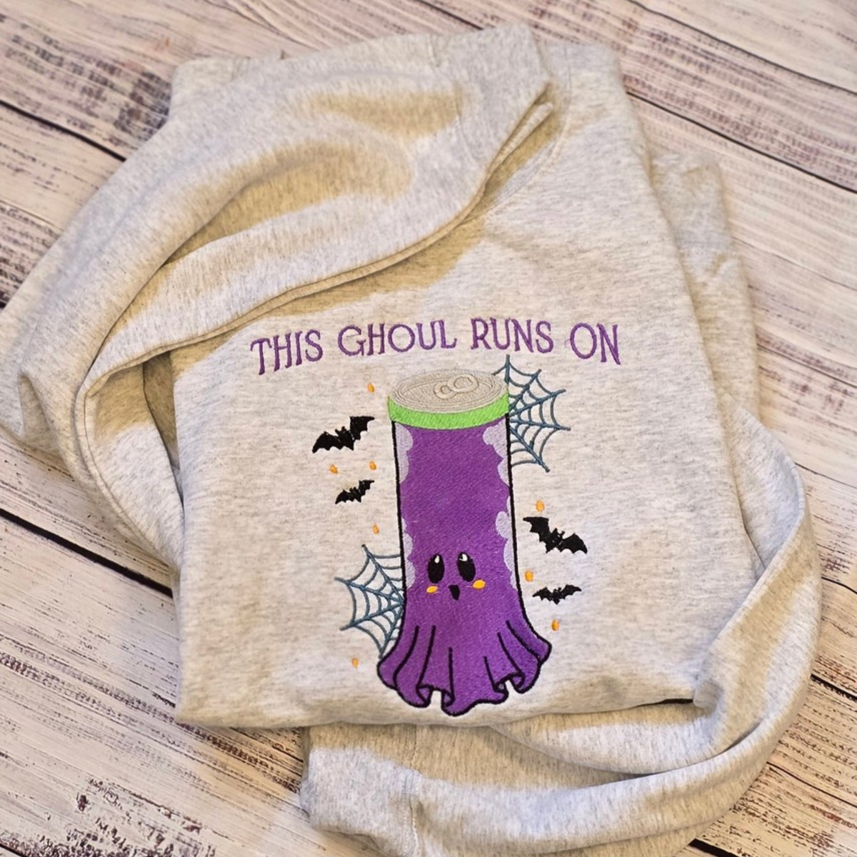 Real Ash embroidered sweatshirt with This Ghoul Runs On purple ghost energy drink design