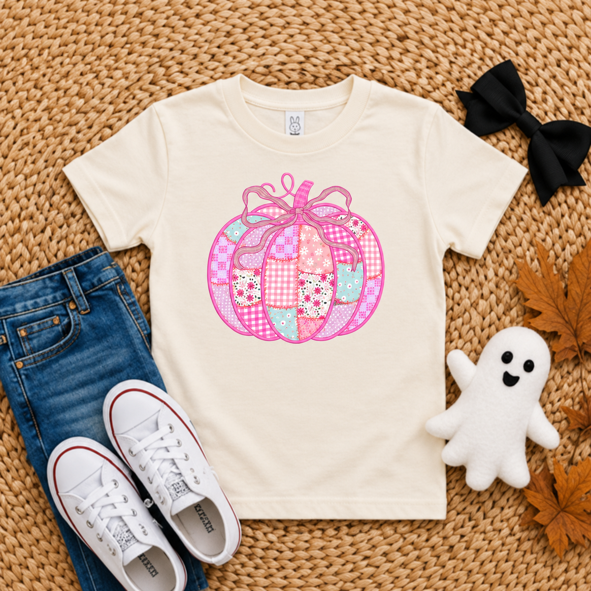 Ivory Rabbit Skins toddler shirt with a pink patchwork bow pumpkin DTG design
