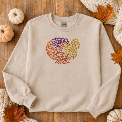 Sand Gildan Softstyle sweatshirt with centered turkey embroidery fall flat lay