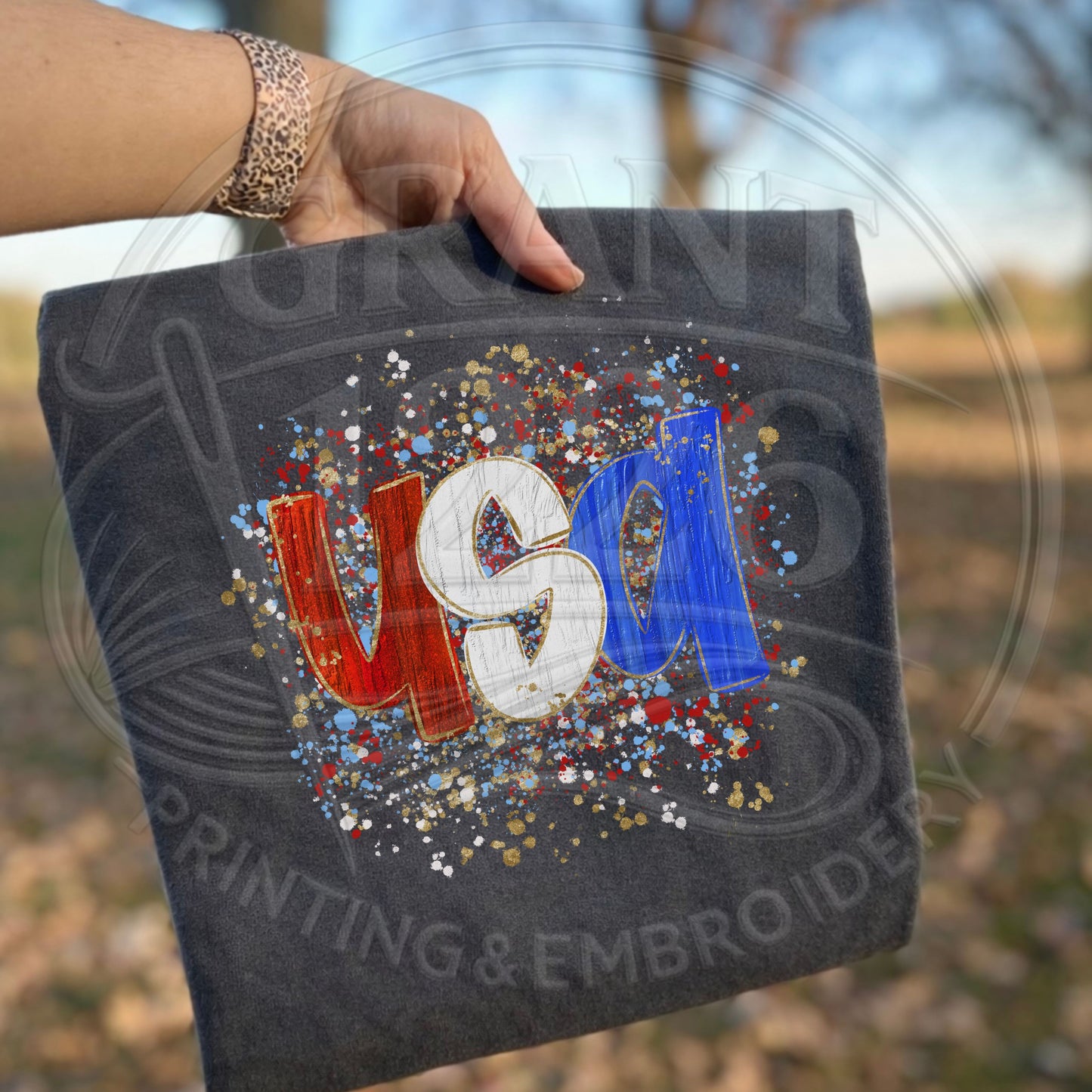 Folded charcoal USA patriotic DTG printed shirt with patriotic splatter paint graphic
