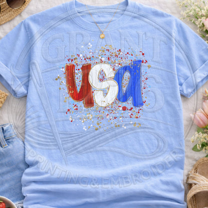 Light blue USA patriotic graphic t-shirt flatlay with trendy splatter design
