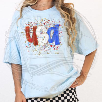 Woman modeling light blue patriotic USA graphic shirt for Fourth of July outfit