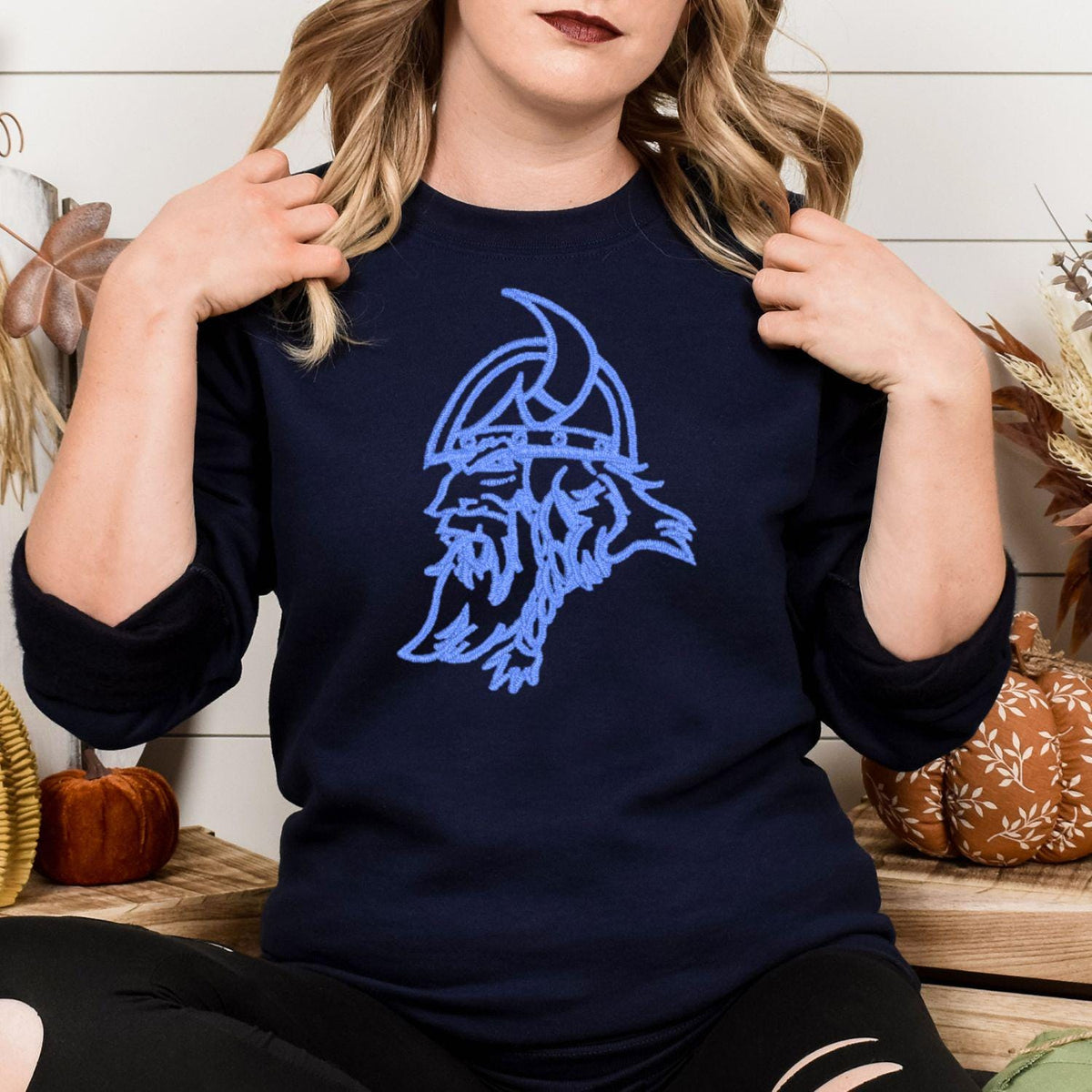 Navy sweatshirt with blue vintage Viking mascot embroidery modeled indoors