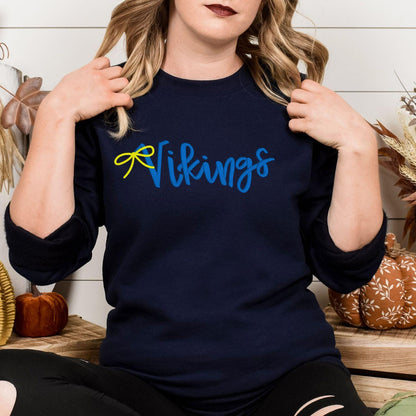 Navy sweatshirt with blue and yellow Vikings script embroidery modeled indoors