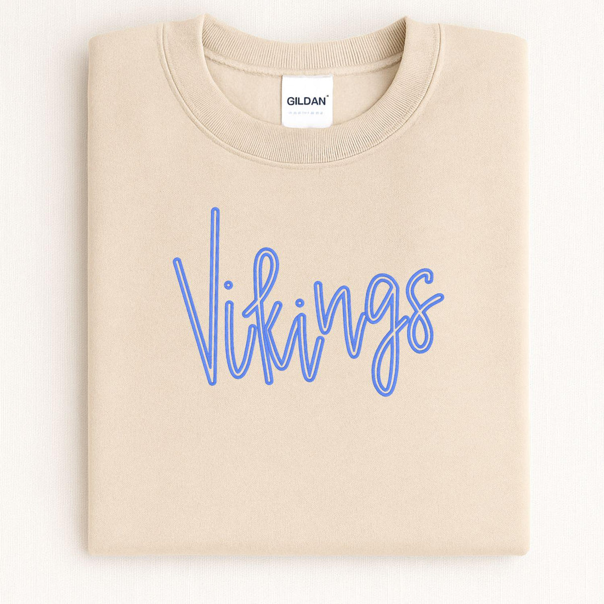 Folded sand crewneck with blue Vikings script embroidery