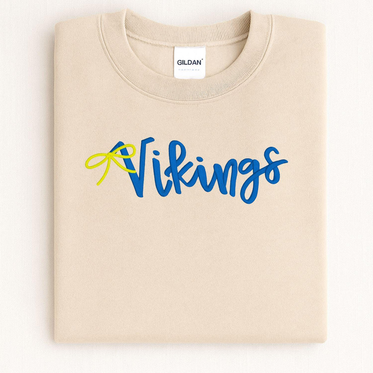 Sand sweatshirt with blue and yellow Vikings script embroidery folded flat
