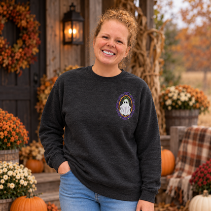 Woman wearing a heathered-black Gildan Softstyle crewneck with a small white framed ghost embroidery on the left chest.