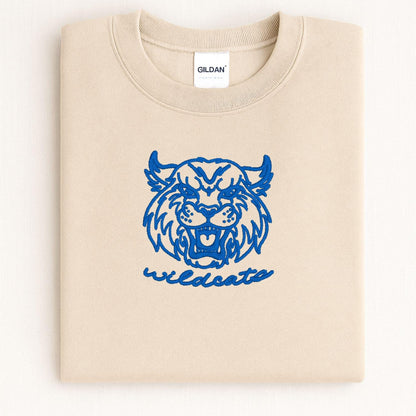 Sand Wildcats mascot embroidered crewneck folded on a light background