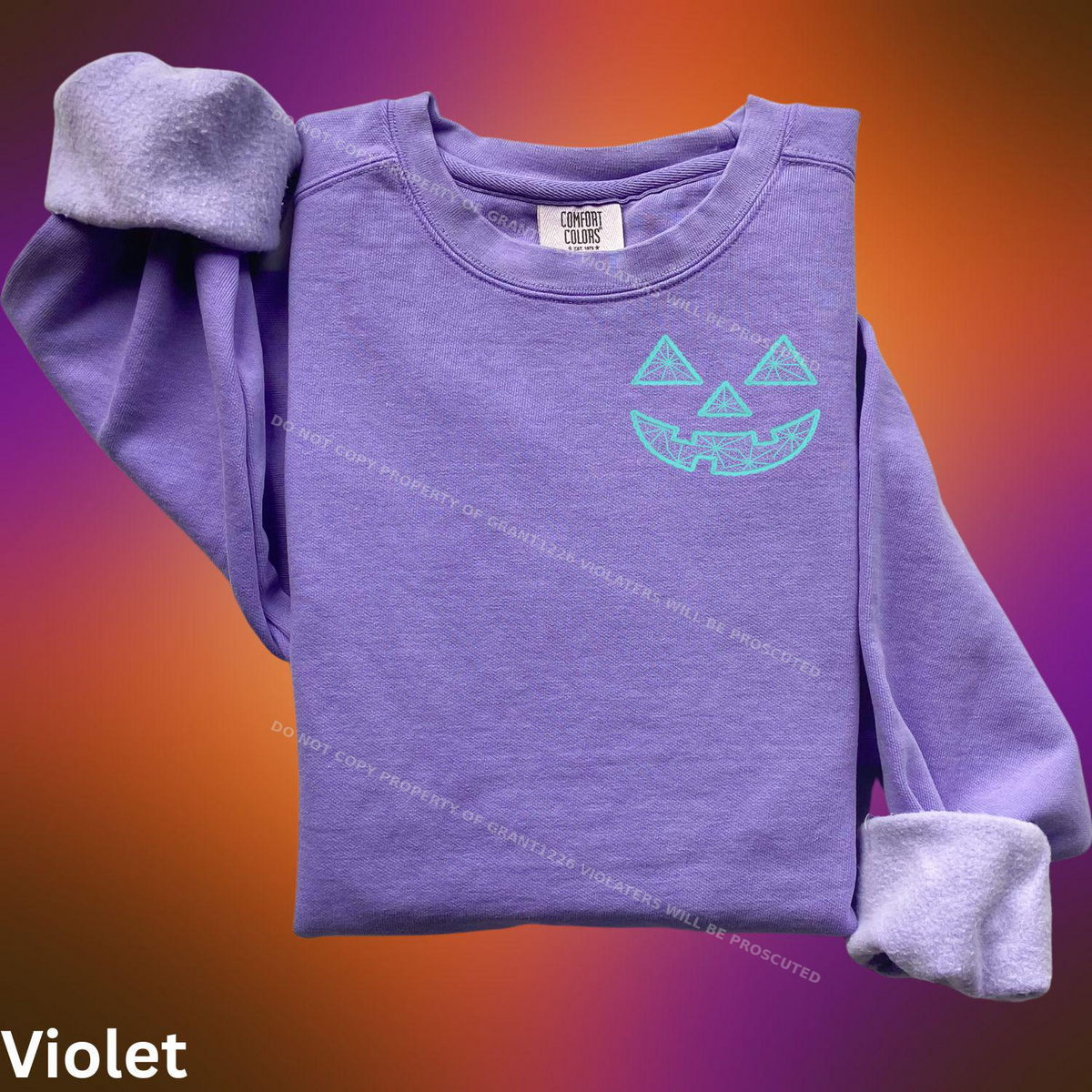 Violet Comfort Colors sweatshirt with turquoise geometric jack-o-lantern embroidery flat lay