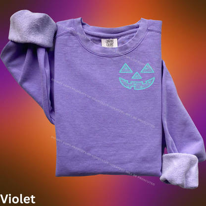 Violet Comfort Colors sweatshirt with turquoise geometric jack-o-lantern embroidery flat lay