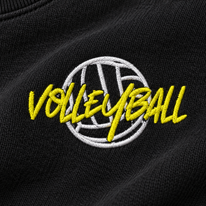 Close-up of white and yellow volleyball embroidery stitched on black sweatshirt fabric