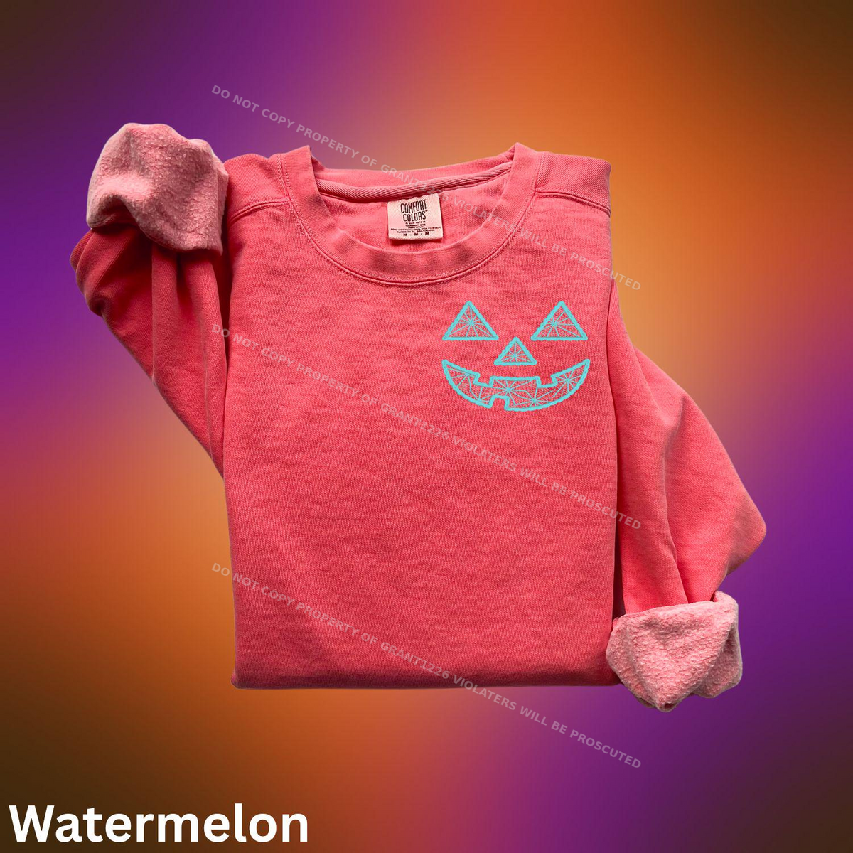 Watermelon Comfort Colors sweatshirt with turquoise geometric jack-o-lantern embroidery flat lay