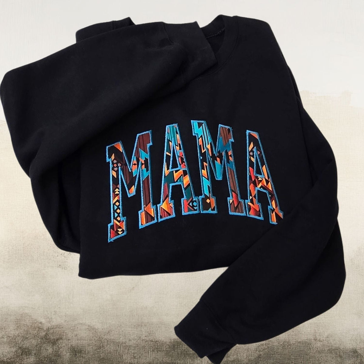 Black Mama sweatshirt with colorful Southwestern geometric embroidery on a neutral background