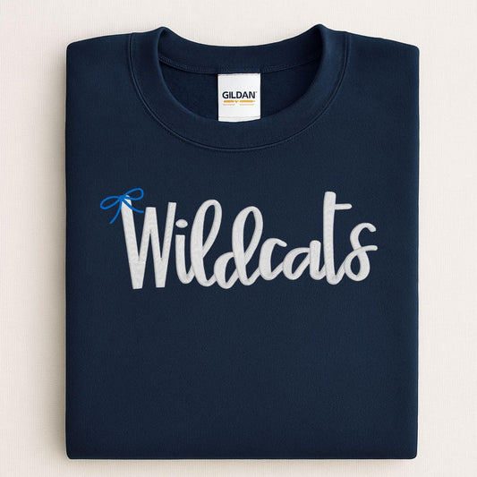 Folded navy crewneck with white Wildcats script and blue bow embroidery
