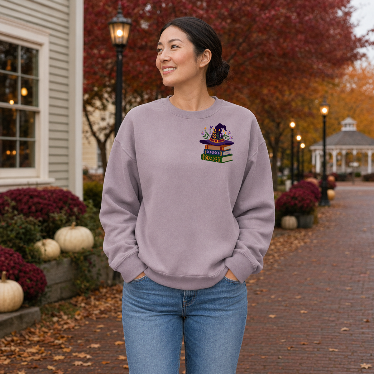 Woman wearing Paragon Gildan Softstyle sweatshirt with witchy books embroidery on the left chest