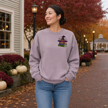 Woman wearing Paragon Gildan Softstyle sweatshirt with witchy books embroidery on the left chest
