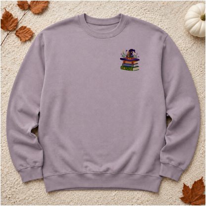 Paragon sweatshirt flat lay with floral witch hat stacked books embroidery on left chest