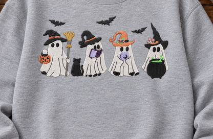 Close-up of four witchy ghosts machine embroidered on a Sport Grey sweatshirt