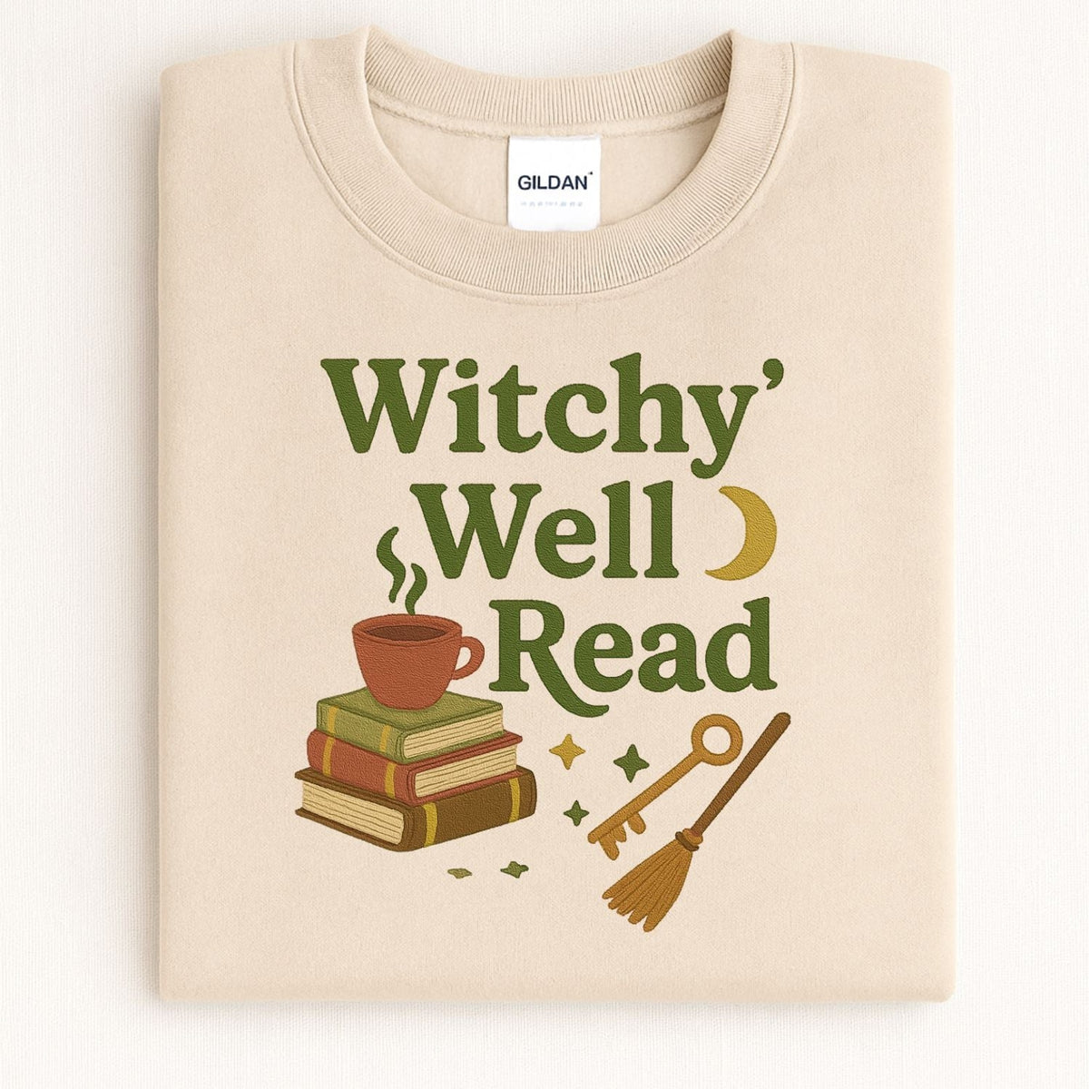 Folded Sand sweatshirt with Witchy Well Read book stack embroidery