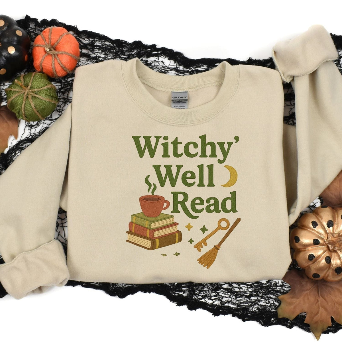 Sand embroidered book lover sweatshirt styled with pumpkins and Halloween decor