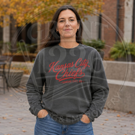 A woman wearing a pepper long sleeve tshirt with 'Kansas City Chiefs' printed in red